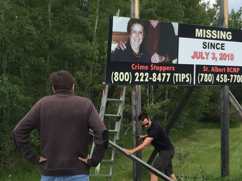 Bret McCann watches as son-in-law Casey Walshe dismantles a sign offering a reward for McCann&#8217;s missing parents Wednesday near Wildwood