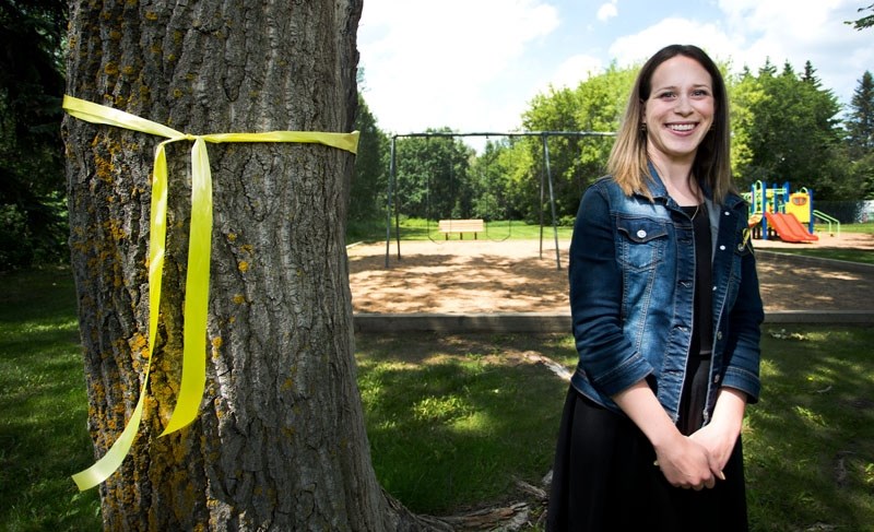 Carly Miller of St. Albert has started tying gold ribbons in area parks to support the return of the Azer children. She poses for a photo at Lacombe Park last Friday. The