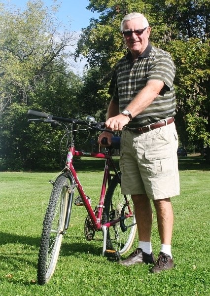 Lou Duigou poses with one of the bicycles that he helped arrange to be gifted to two Syrian families that relocated here last year.