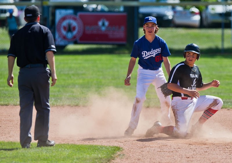 SAFE OR OUT? â€“ Nick Arlia of St. Albert Cardinals Red and Derek Lofstrand of the Lacombe Dodgers look to see what the call is at second base at the U18 midget AA westerns