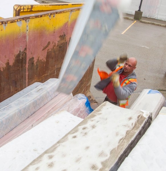 TO THE CURB â€“ A public works employee hurls a mattress at a large item drop-off event at the Jack Kraft facility. This September