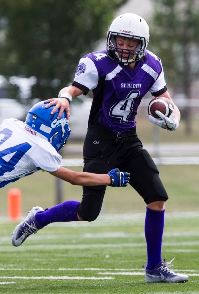 KEEP AWAY â€“ Jacob King of the junior varsity bantam St. Albert Fury fends of a tackler in exhibition action against the Spruce Grove Cougars last weekend. The Fury lost