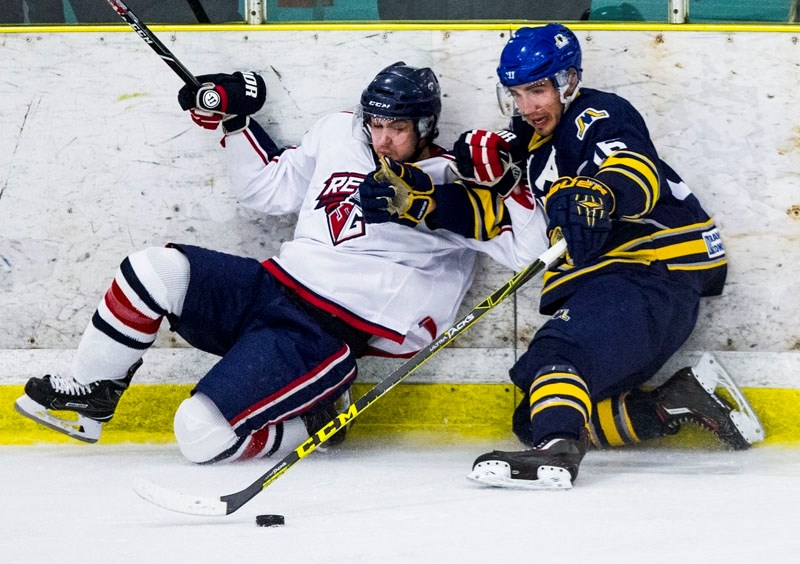 BOARD WORK â€“ Cam Mazur of the St. Albert Merchants takes a poke at the puck after rubbing out a Spruce Grove player against the boards in Sunday&#8217;s junior B league