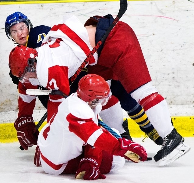 CLUMPED TOGETHER â€“ Chris Motoska of the St. Albert Merchants is tangled up with a pair of North Edmonton Red Wings in Sunday&#8217;s junior B game at Akinsdale Arena. The