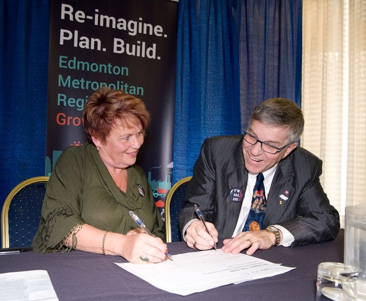 THEY&#8217;RE ALL IN â€“ Strathcona County Mayor Roxanne Carr and St. Albert Mayor Nolan Crouse sign off on the new Edmonton Metropolitan Region Growth Plan moments after it