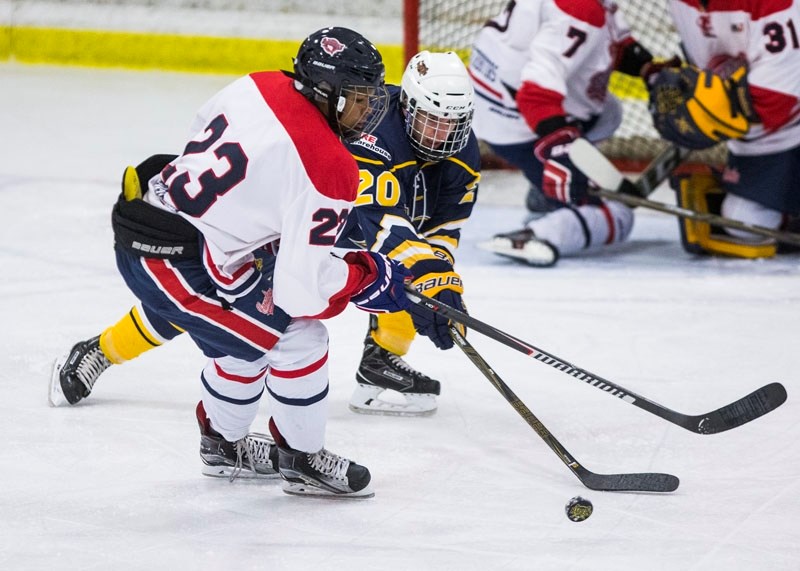 PLAYING THE PUCK â€“ Samuel Smith-Ackerl of the St. Albert Tire Warehouse Raiders reaches for the puck while checked by Daniel Ostrosser of the Canadian Athletic Club in the
