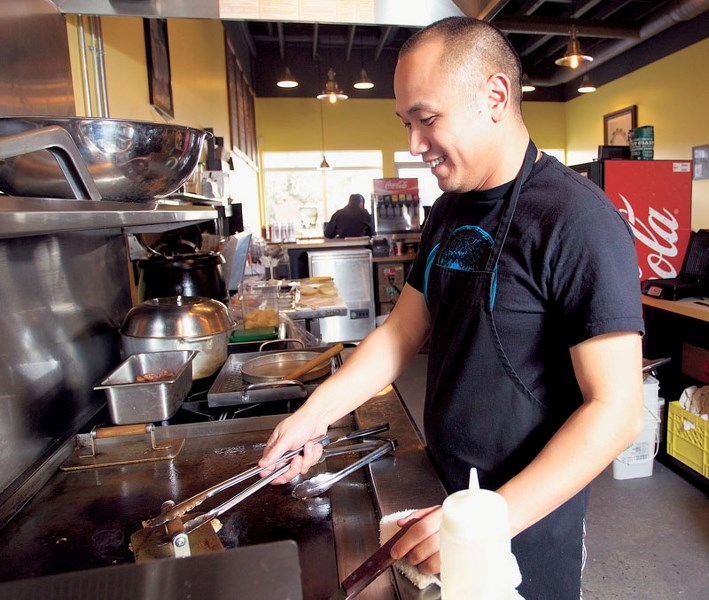 Owner Tu Le prepares burgers for a customer at Jack&#8217;s Burger Shack.