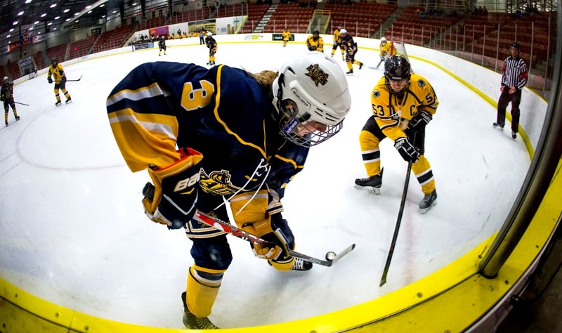 CORNERED â€“ Kamea Brezovski of the bantam elite St. Albert Raiders plays the puck while pressured by Julia Zygun