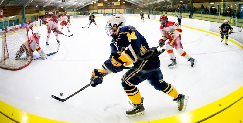 CORNER WORK â€“ Eddie Gallagher of the St. Albert Tire Warehouse Raiders plays the puck in the corner of the Akinsdale rink in Sunday&#8217;s midget AAA game against the