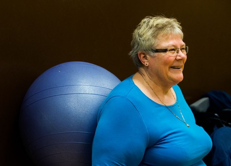 Ivy Witoshynski shares a laugh with her classmates as she uses an exercise ball during a recent workout for people with MS.