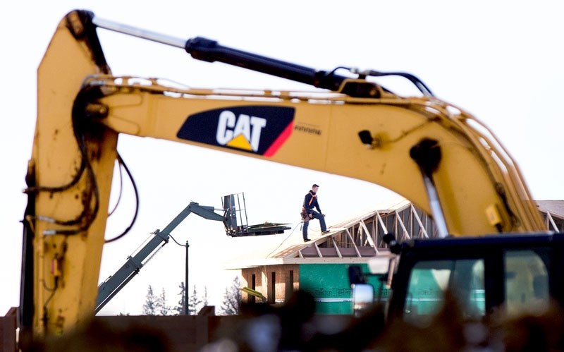 NATURE&#8217;S LOSS â€“ A construction worker stands atop the roof of a house under construction at the Jensen Lakes site on Thursday November 24