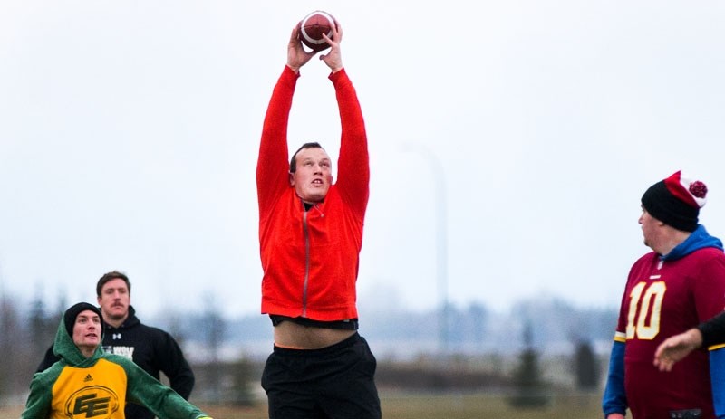 GRIPPING CATCH â€“ Mark Button reaches to squeeze the pigskin during the annual Snow Bowl at the St. Albert Rugby Football Club on Sunday. SARFC players and club members