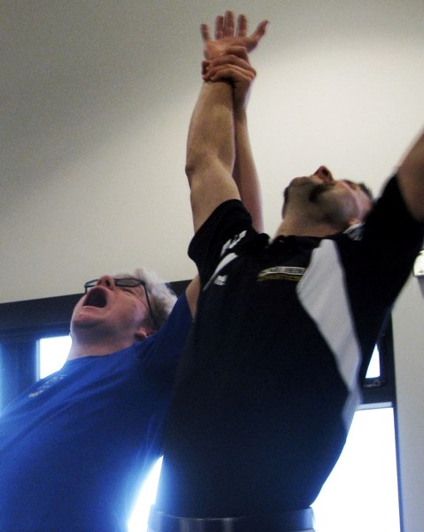 James Wright raises the victorious hands of be-handlebar-ed Troy Bontus as he defeats SACHS teacher Evan Holstein. The two held a month-long Movember competition