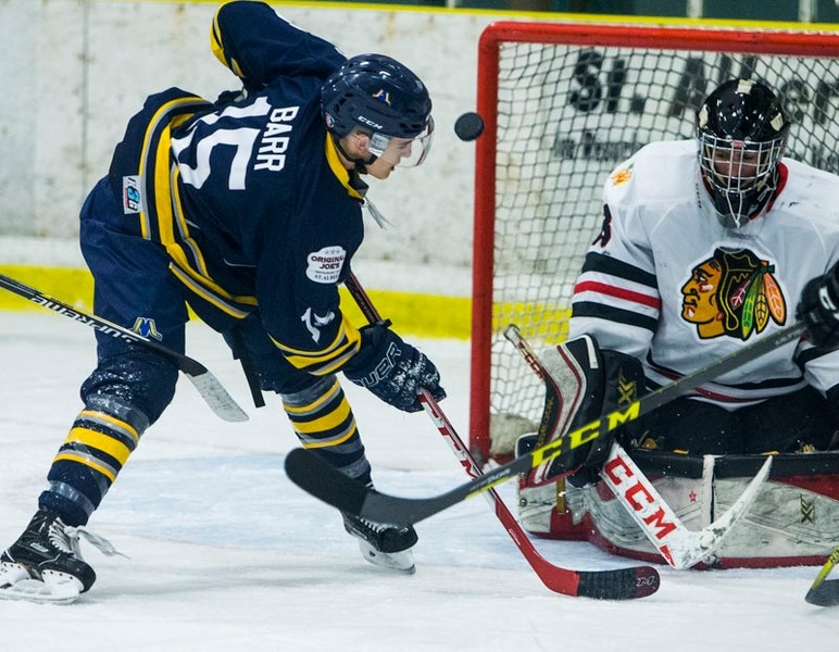 LOOKING TO SCORE â€“ Andy Barr of the St. Albert Merchants eyes up a scoring chance against netminder Adam Holowach of the Beverly Warriors in Sunday&#8217;s junior B game at 