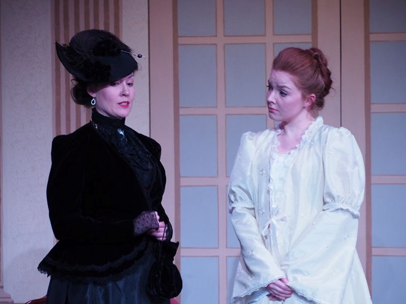 Mrs. Erlynne (Marsha Amanova) and Lady Windermere (Miranda Broumas) enjoy an eye-opening farewell in Lady Windermere&#8217;s Fan now playing at Walterdale Theatre.