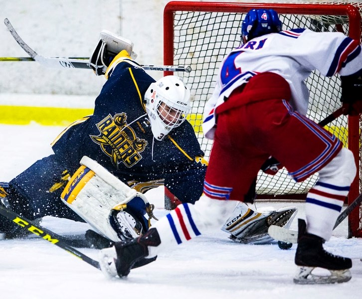 SAVING GRACE â€“ Mitchell Reidy of the St. Albert Raiders reaches back to scoop the puck away from Dylan Anhorn of the Calgary Raiders in Sunday&#8217;s midget AAA game at