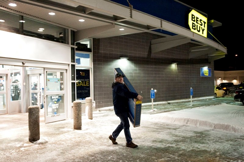 Weston Koroluk of Morinville carries away a TV at the Best Buy in St. Albert at the 6 a.m. opening on Boxing Day.