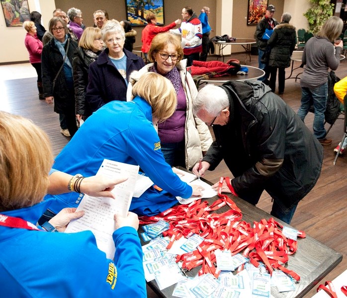 VOLUNTEERS HURRY HARD – Volunteers for the Jiffy Lube Alberta Scotties Tournament of Hearts line up for their identification badges