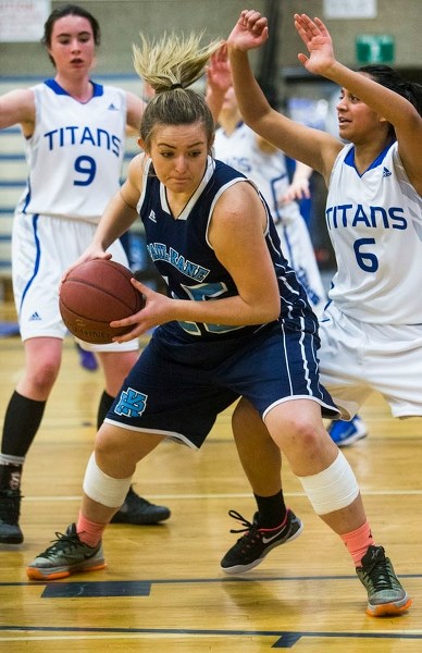 SAFEGUARDING – Deanna Missins of the Paul Kane Blues protects the ball while pressured by the Harry Ainlay Titans in Wednesday&#8217;s metro Edmonton division one senior