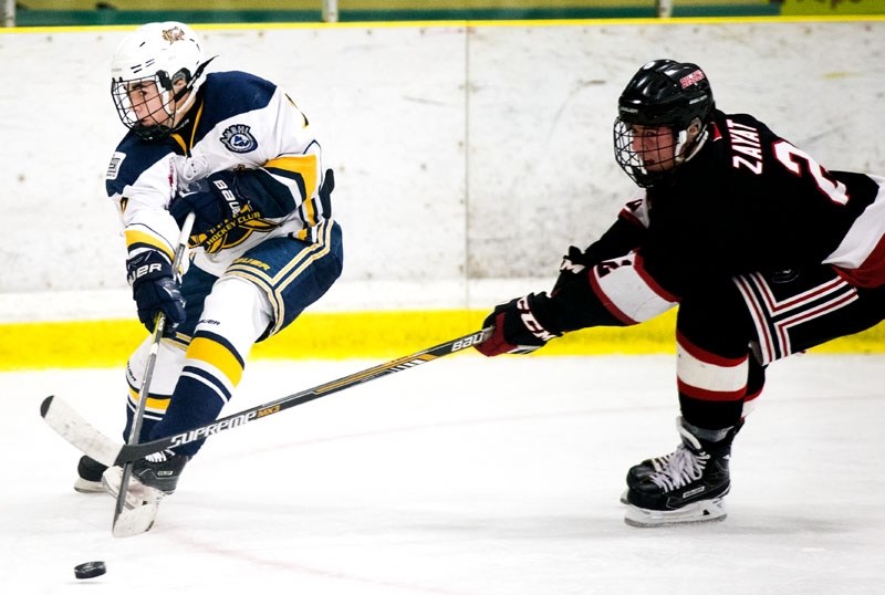 SABRE RATTLING â€“ Matt Savoie of the St. Albert Gregg Distributors Sabres plays the puck while challenged by Jack Zayat of the Calgary Bisons in the Alberta Major Bantam