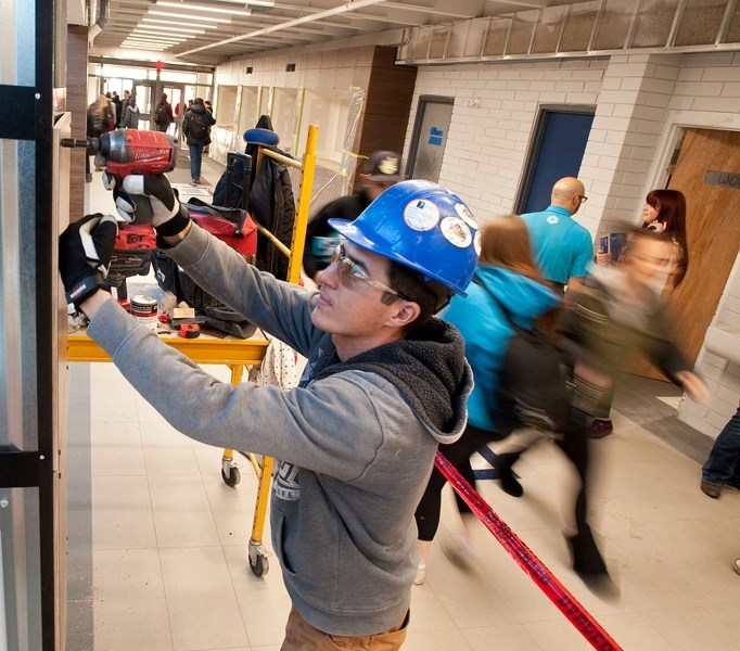 UNDER CONSTRUCTION – Construction worker Eugeniu Turcan of CCS Contracting Ltd. works while students stream by in the hallway during continuing renovations at Sturgeon