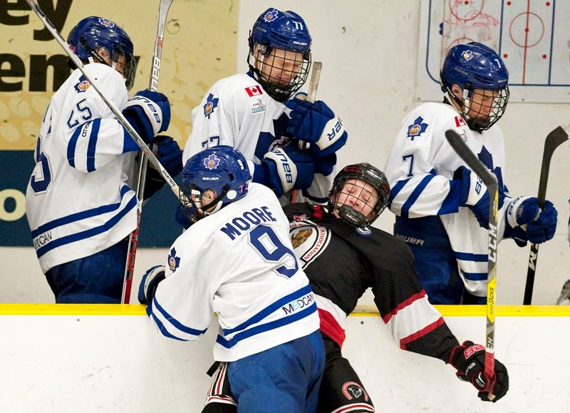 CRUNCHED – Lleyton Moore of the Toronto Marlboros slams Jayden Grubbe of the Calgary Bisons into the Toronto bench during Thursday&#8217;s game at the John Reid Memorial