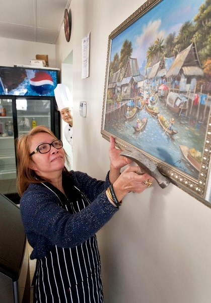 NEW THAI RESTAURANT –Tanapan &#8216;Kanya&#8217; Andreeff tries to decide where to hang a picture in her new restaurant while her chef