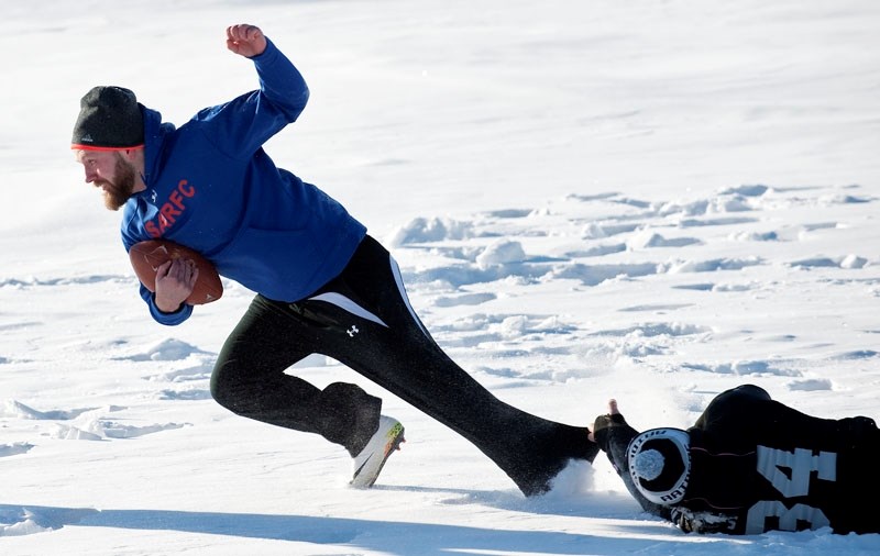 DESPERATION TACKLE â€“ Andrew Marsden attempts to slow down Jon Anderson by grabbing his pant leg at the Snow Bowl