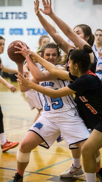 TIGHT CHECKING – Deanna Missins of the Paul Kane Blues is pressured by the Jasper Place Rebels in Wednesday&#8217;s metro Edmonton division one contest at Paul Kane. The