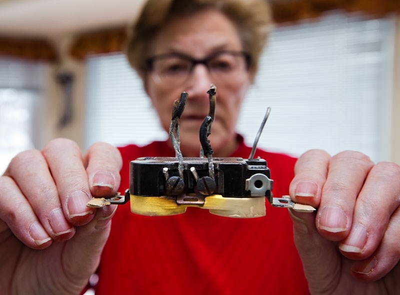 Maura McGarrigle of St. Albert holds up one of two burnt wall sockets that were replaced in her home recently. McGarrigle and her husban Aiden had an electrician come into