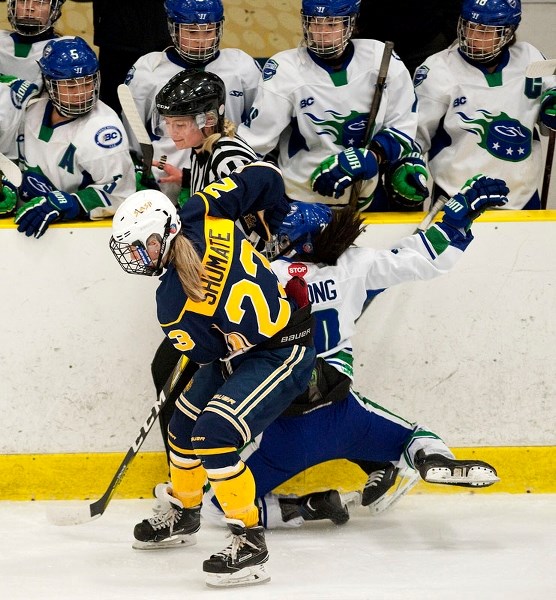 TAKEOUT – Alexis Shumate of the St. Albert Slash angles off Naomi Choong of the Greater Vancouver Comets into Maya Frederickson