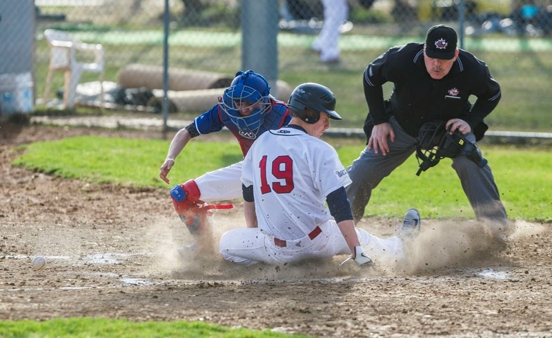 PLAY AT THE PLATE – Mike Brisson of the St. Albert Cardinals slides home under the watchful eye of umpire Marty Stubbs in Wednesday&#8217;s doubleheader against the South