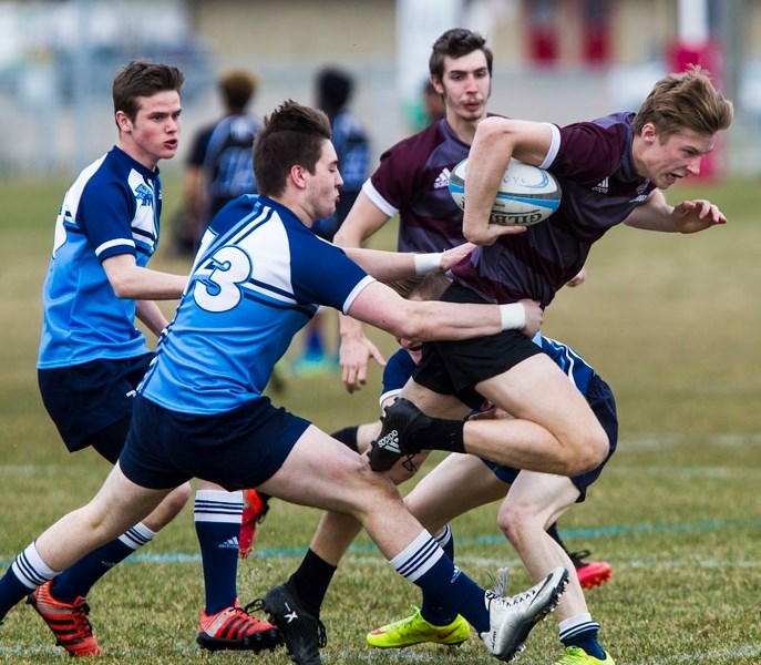 FORWARD DRIVEN – James McCabe (13) and a partially hidden Robert Putt of the Paul Kane Blues attempt to slow down Liam Douglas of the Bellerose Bulldogs during the Gareth