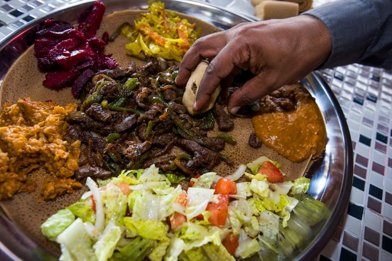 The Eritrean-Ethiopian dish of beef chacha surrounded by half a dozen vegetarian specialties is served on a platter with injera