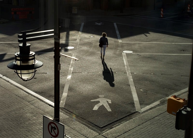 A woman uses the criss cross pedestrian intersection at Perron and St. Anne