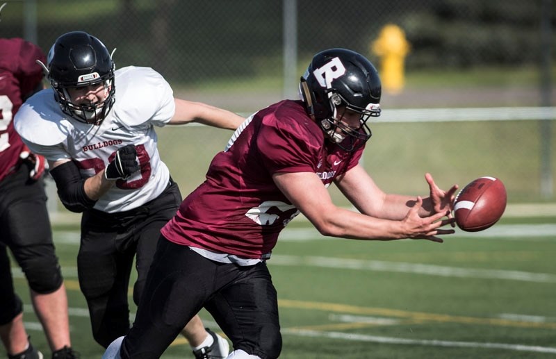 DAWG BOWL IV â€“ Brett Yost of Team Cardinal (Guy) mishandles a pitch as Bronson Wilke of Team White (Hill) bears down on the Bellerose Bulldog at the sixth annual Dawg Bowl