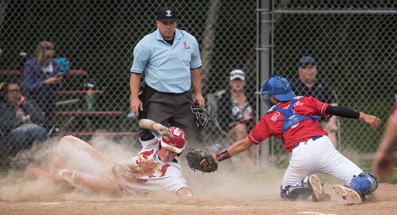 SAFE AT HOME â€“ Jackson Moffat of the St. Albert Cardinals beats the tag of South Jasper Place Jays&#8217; catcher Jean-Luc Bussieres in front of home-plate umpire Kevin