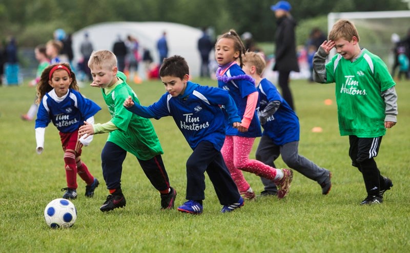 FOOTY FUN â€“ Youths chase after the ball at the Timbits Jamboree on Saturday at Riel Park. The season windup for U4