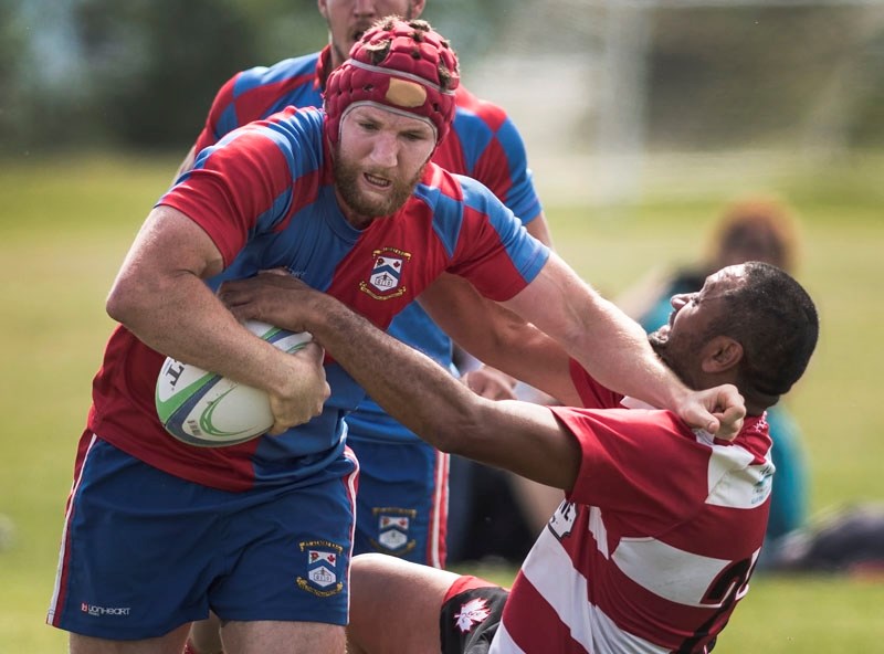 UNSTOPPABLE – Kyle Gilmour of St. Albert powers his way past a Calgary Saint in Saturday&#8217;s premier men&#8217;s match at the St. Albert Rugby Football Club. Gilmour