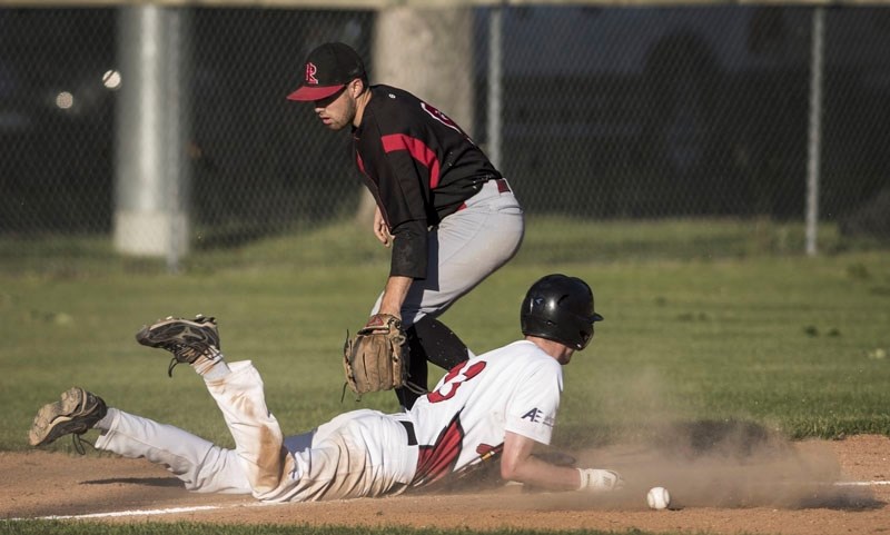 DUST-UP â€“ Jory Lutzman of the St. Albert Junior Cardinals slides safely back to third after the throw to Austin Watamaniuk of the Westlock Red Lions was dropped during last 