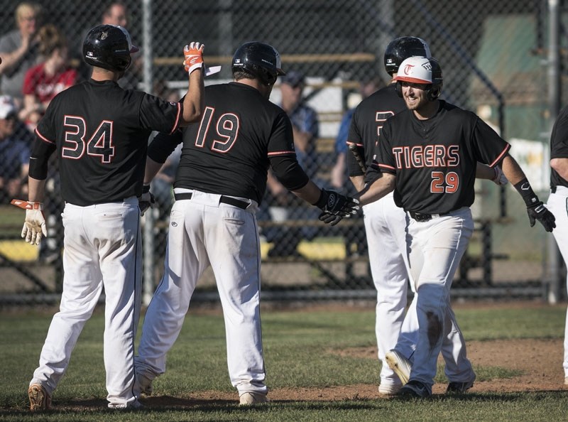 HOMER â€“ Kevin Czarnecki of the St. Albert Tigers is greeted by Jessy Beley (19) and Dan Curtis (34) after stroking a home run against the Sherwood Park Athletics in the