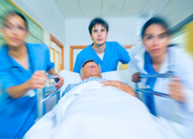 Nurses rush stretcher down a hospital hall