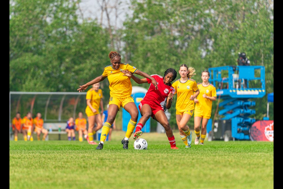 Ojong Tabot (left) battles with an opposing player for a ball.