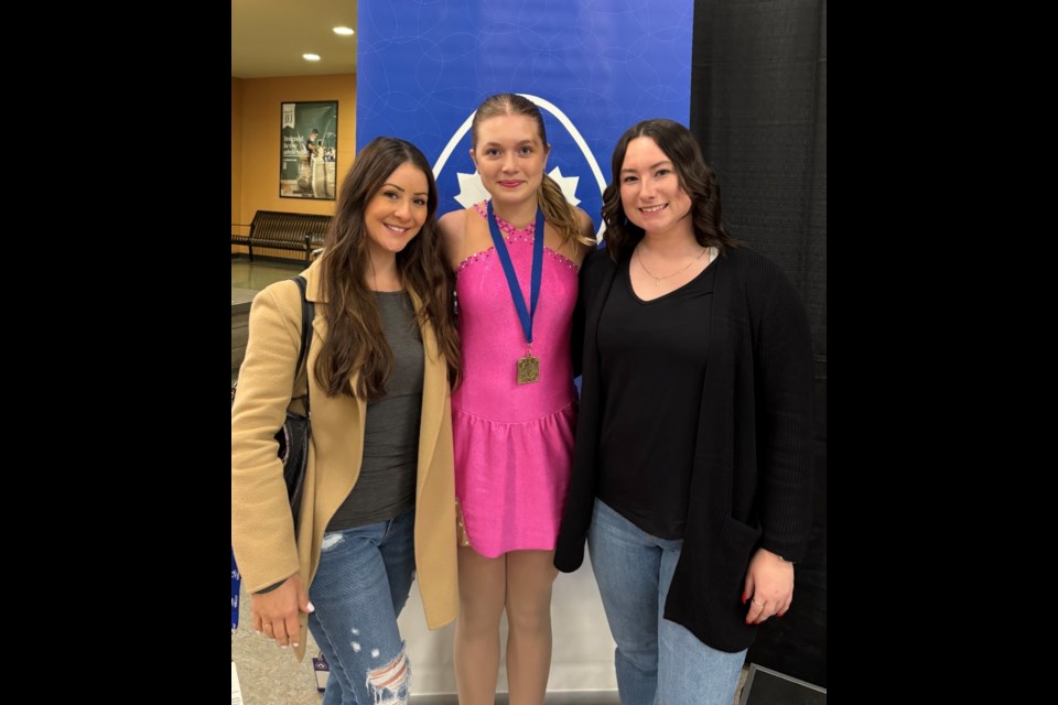 Coach Alex-Marie Arrotta (left) and Harper MacCauley (middle), after Harpers stunning double gold at the Wild Rose Invitational, just days after injury. 