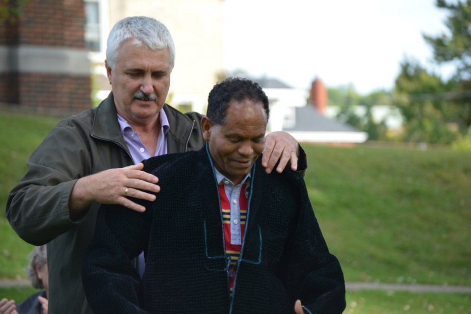 Volodymyr Postyrnatz presents Dr. Geza Wordofa with a handmade coat -- an endorsement from the people he has helped.
