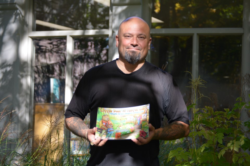 S.P. Joseph Lyons with his award-winning book Little Bear in Foster Care in front of his local library in St. Marys 