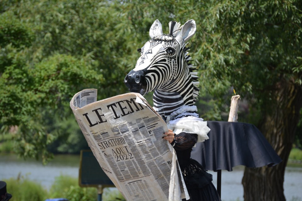 Zebrelle of the Jacques and Zebrelle circus show reads up on Stratford news at their Aug. 7 performance.