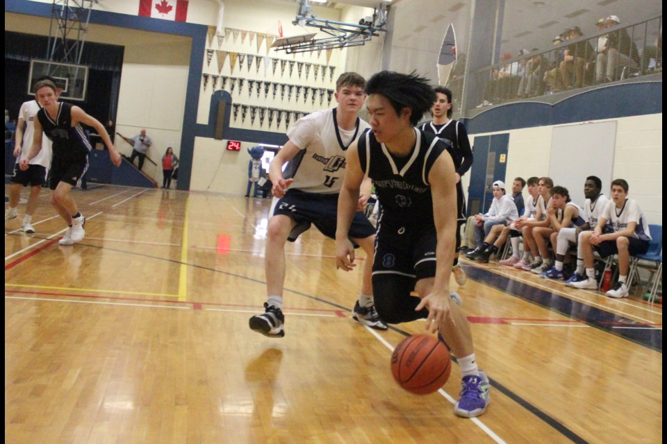 Alen Chen of Mitchell Blue Devils drives to the hoop against a London Christian High defender at the WOSSAA 'A' boys basketball championship. Chen scored 14 points for the Blue Devils. 