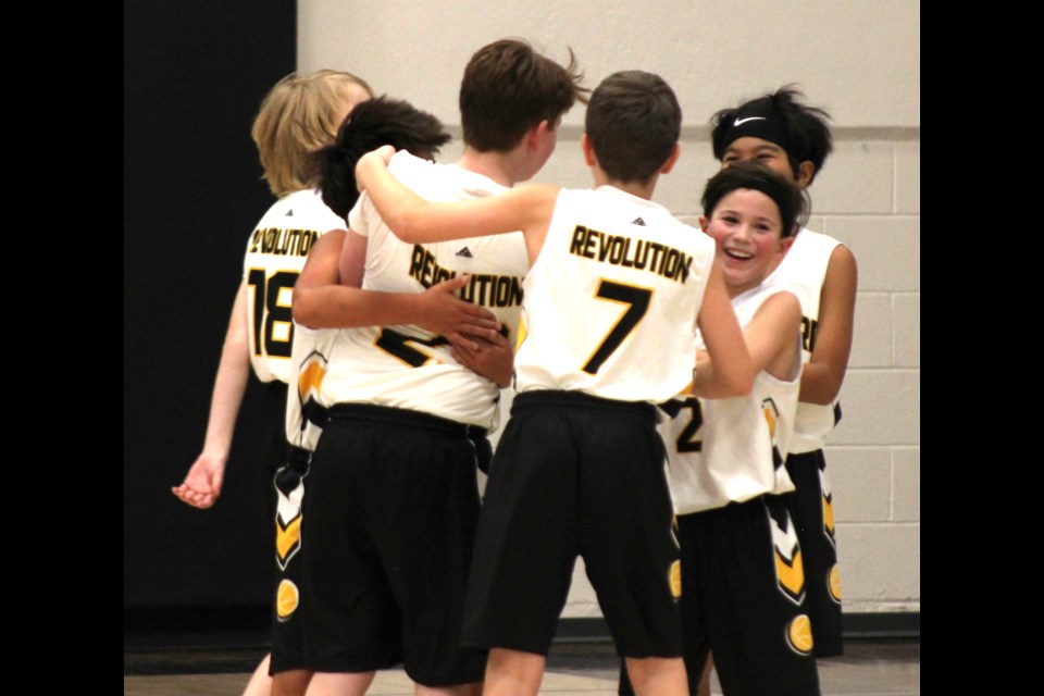 Team members congratulate Owen Abercrombie after hitting a three pointer at the buzzer. 