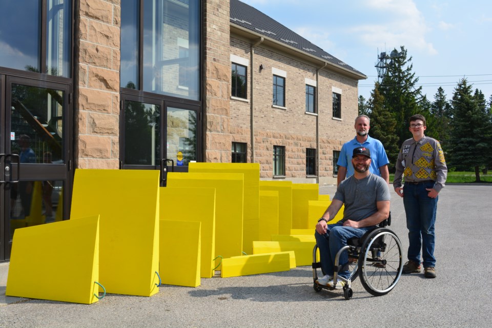 Roger Koert, Jonathan DeWeerd, and Nathaniel DeWeerd posing next to the newly built accessibility ramps. 